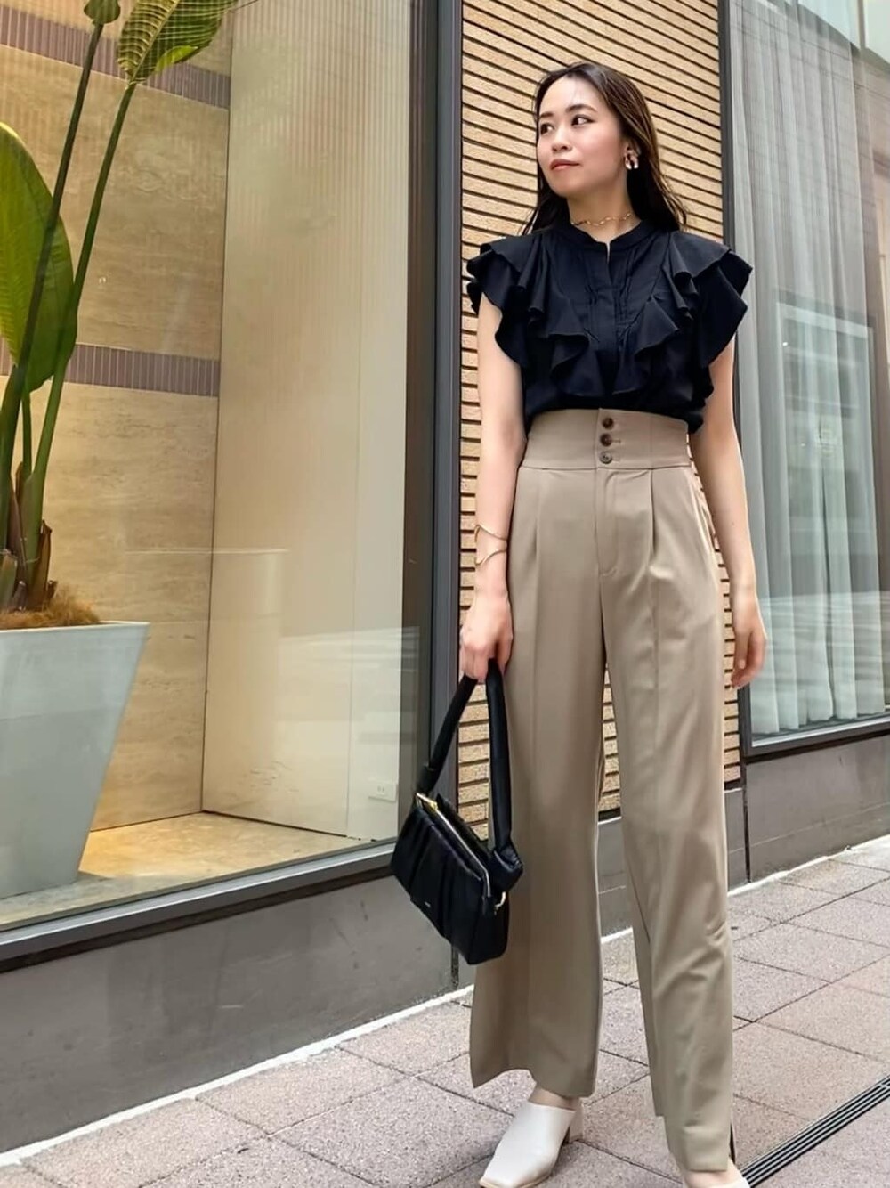 ベージュ系のその他パンツ、ブラック系のハンドバッグ、ブラック系のシャツ/ブラウスを着用したレディースの夏コーディネートの1枚目の写真