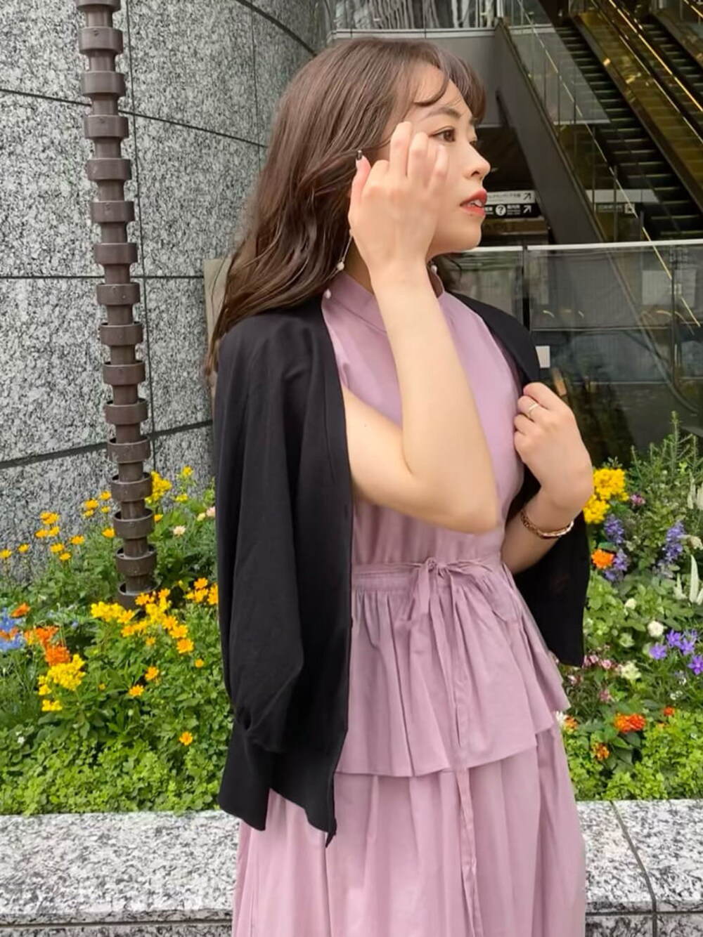 パープル系のワンピース、ブラック系のサンダル、ベージュ系のハンドバッグを着用したレディースの夏コーディネートの1枚目の写真