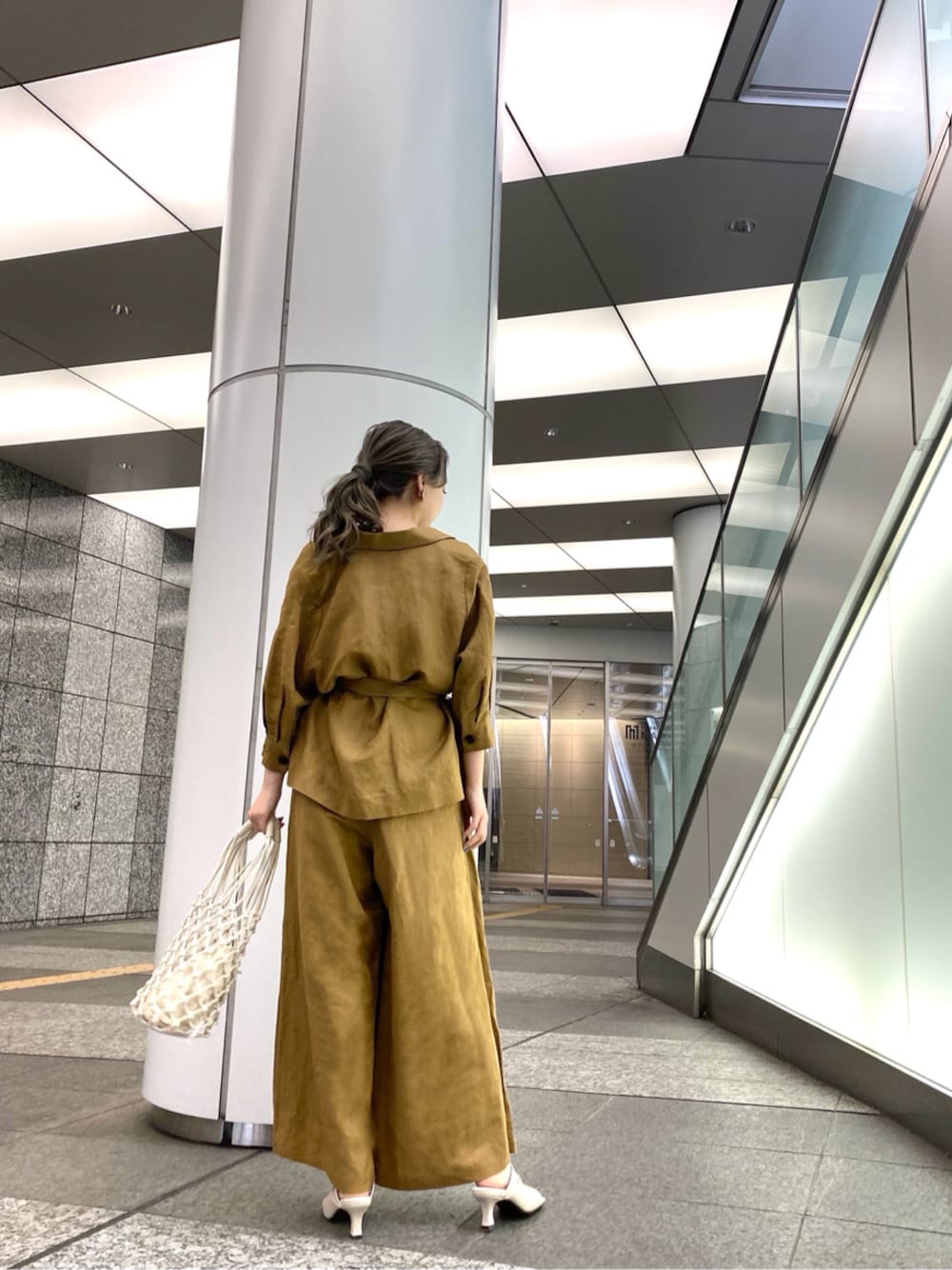 ブラウン系のテーラードジャケット、ブラウン系のその他パンツ、ホワイト系のサンダルを着用したレディースの春コーディネートの1枚目の写真