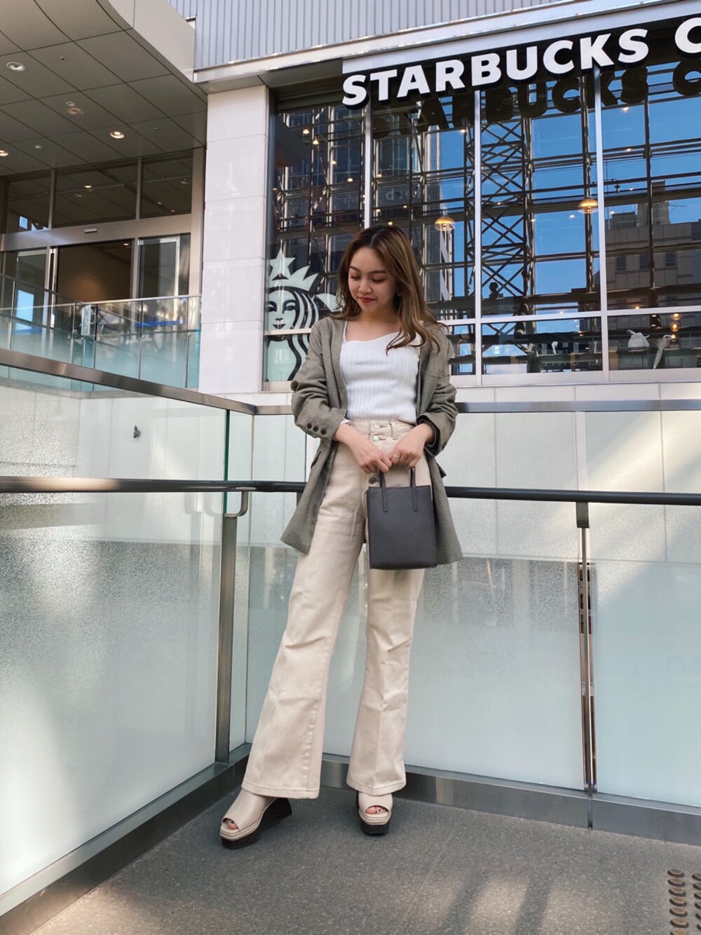 ホワイト系のその他パンツ、ホワイト系のサンダル、ベージュ系のハンドバッグを着用したレディースの春コーディネートの1枚目の写真