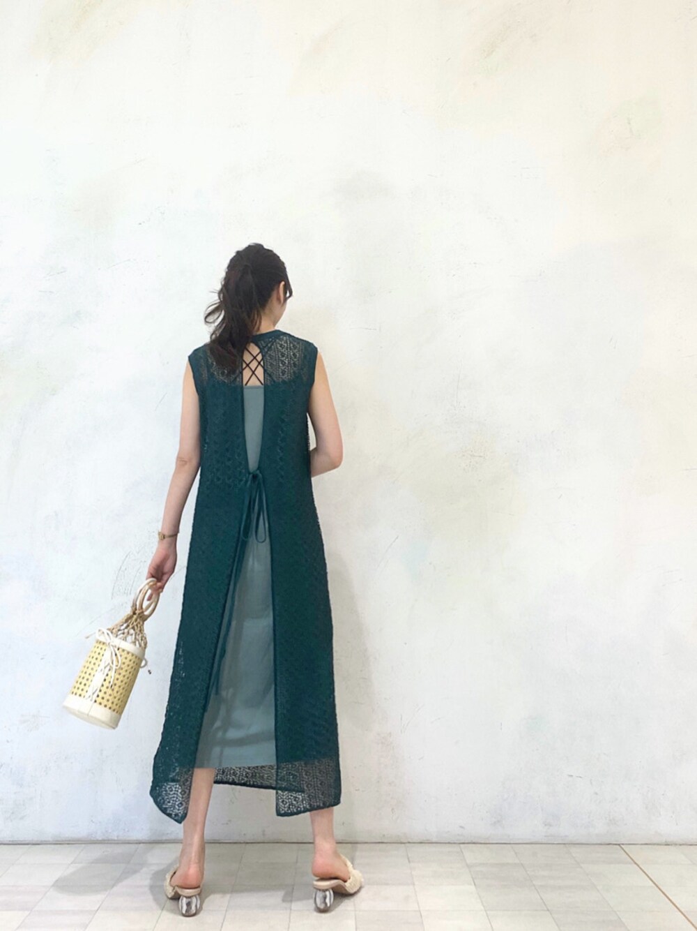 ホワイト系のサンダル、グリーン系のワンピース、ホワイト系のハンドバッグを着用したレディースの春コーディネートの1枚目の写真