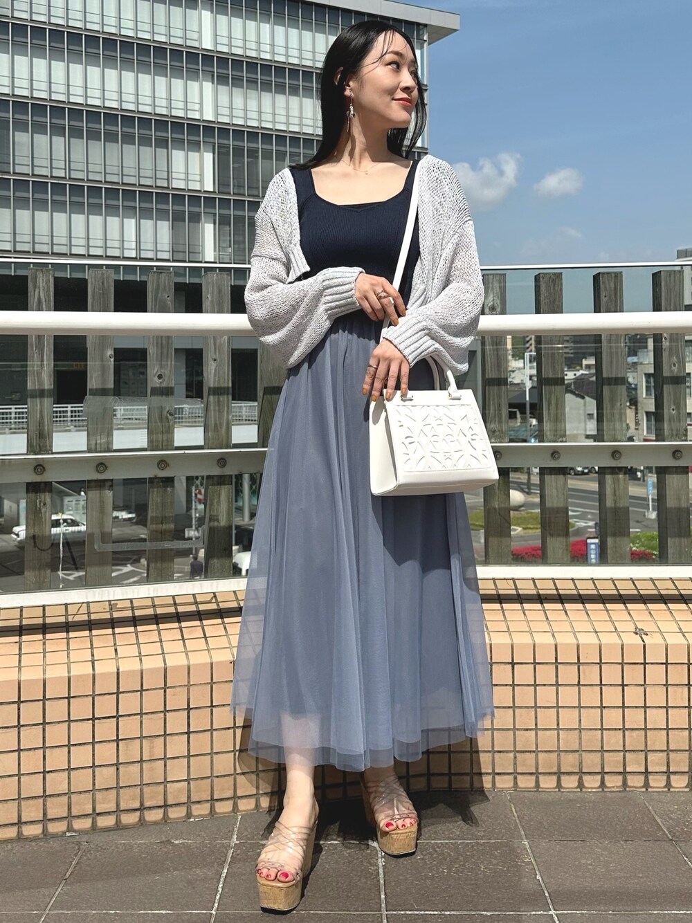 グレー系のカーディガン/ボレロ、ホワイト系のショルダーバッグ、ブルー系のワンピースを着用したレディースの春コーディネートの1枚目の写真