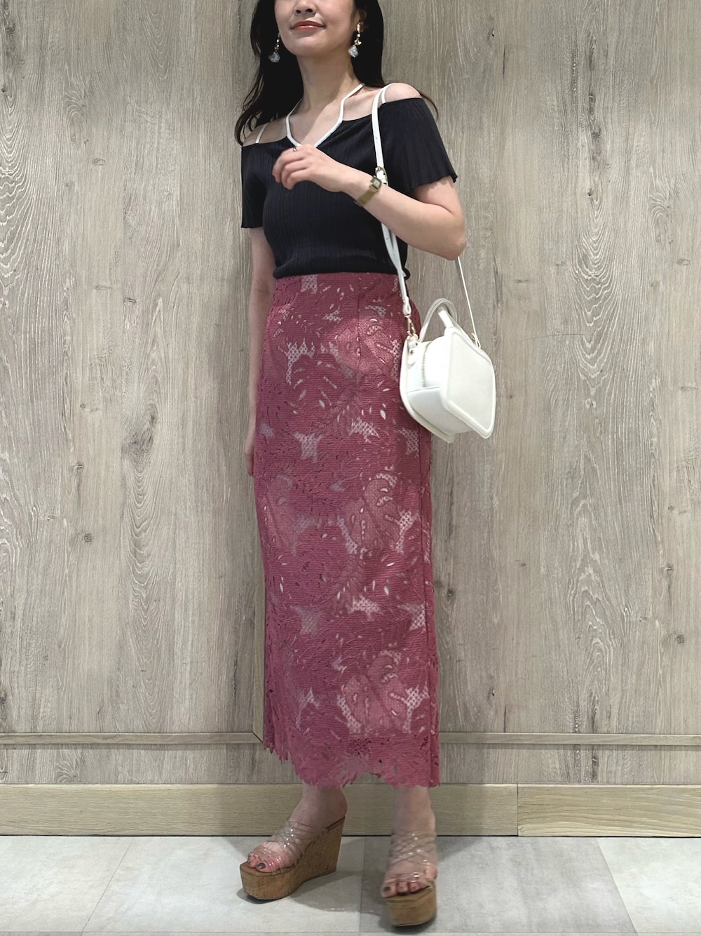 ホワイト系のハンドバッグ、グレー系のニット/セーター、ピンク系のスカートを着用したレディースの春コーディネートの1枚目の写真