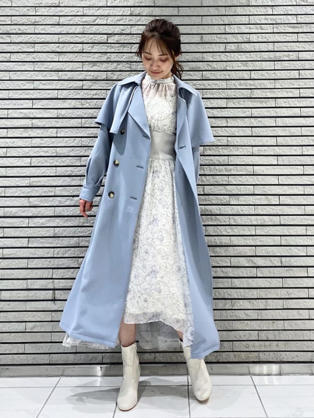 ブルー系のトレンチコート、ホワイト系のワンピース、ホワイト系のその他シューズを着用したレディースの冬コーディネートの1枚目の写真