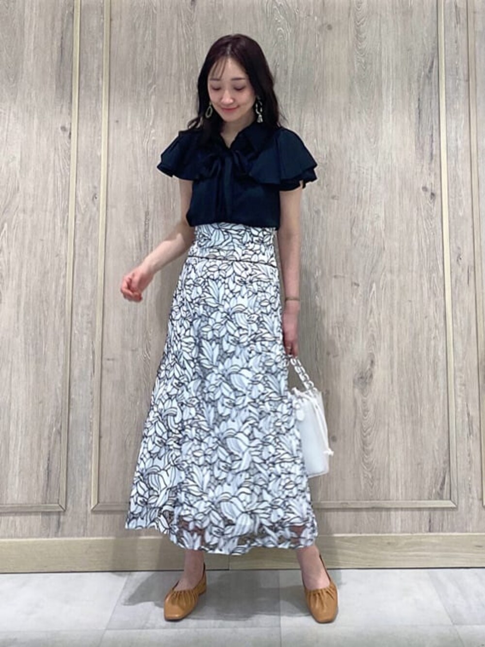 ブラック系のTシャツ/カットソー、ブラウン系のパンプス、ホワイト系のハンドバッグを着用したレディースの春コーディネートの1枚目の写真