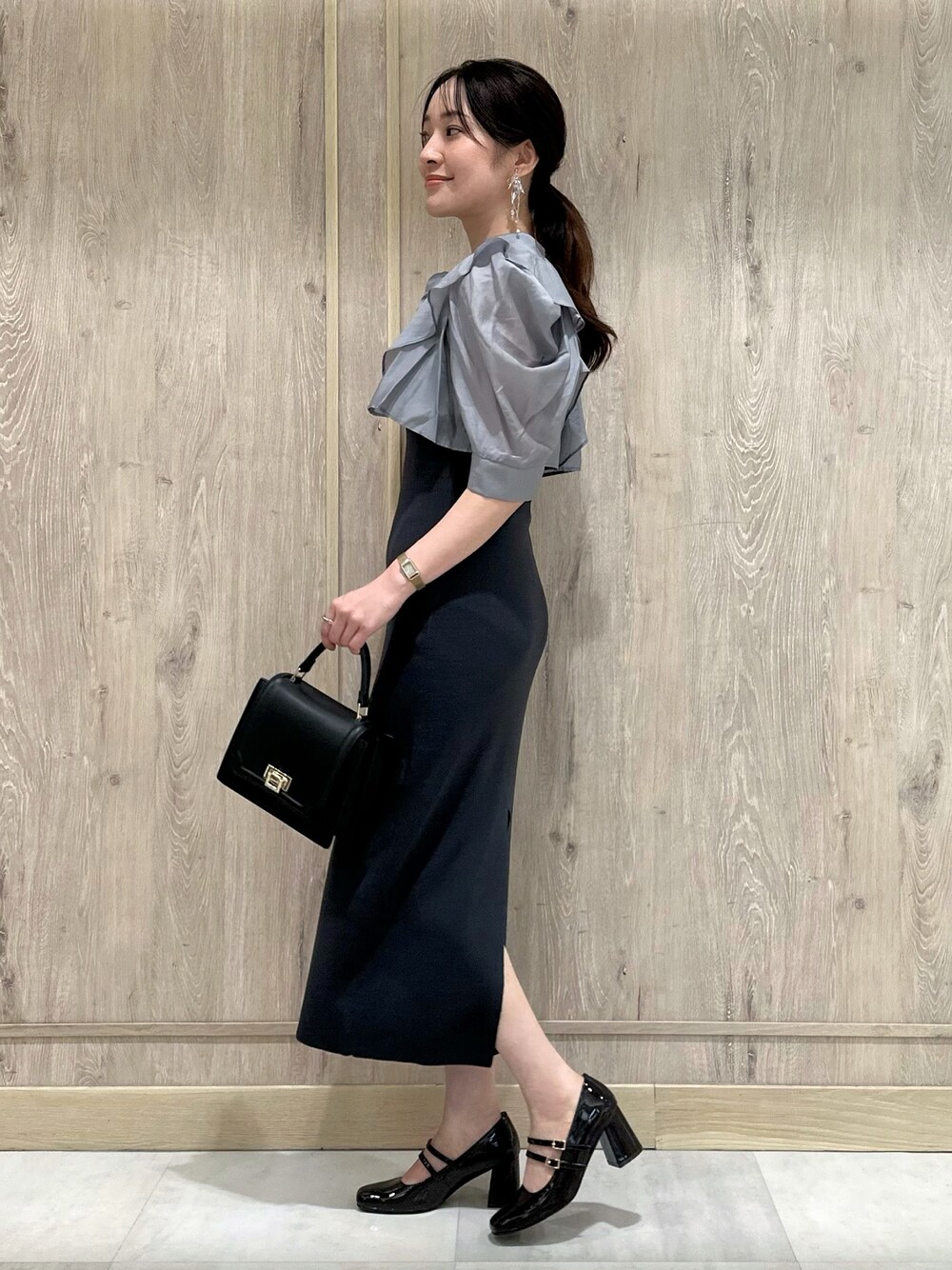 ブラウン系のパンプス、ブラック系のハンドバッグ、グレー系のワンピースを着用したレディースの夏コーディネートの1枚目の写真