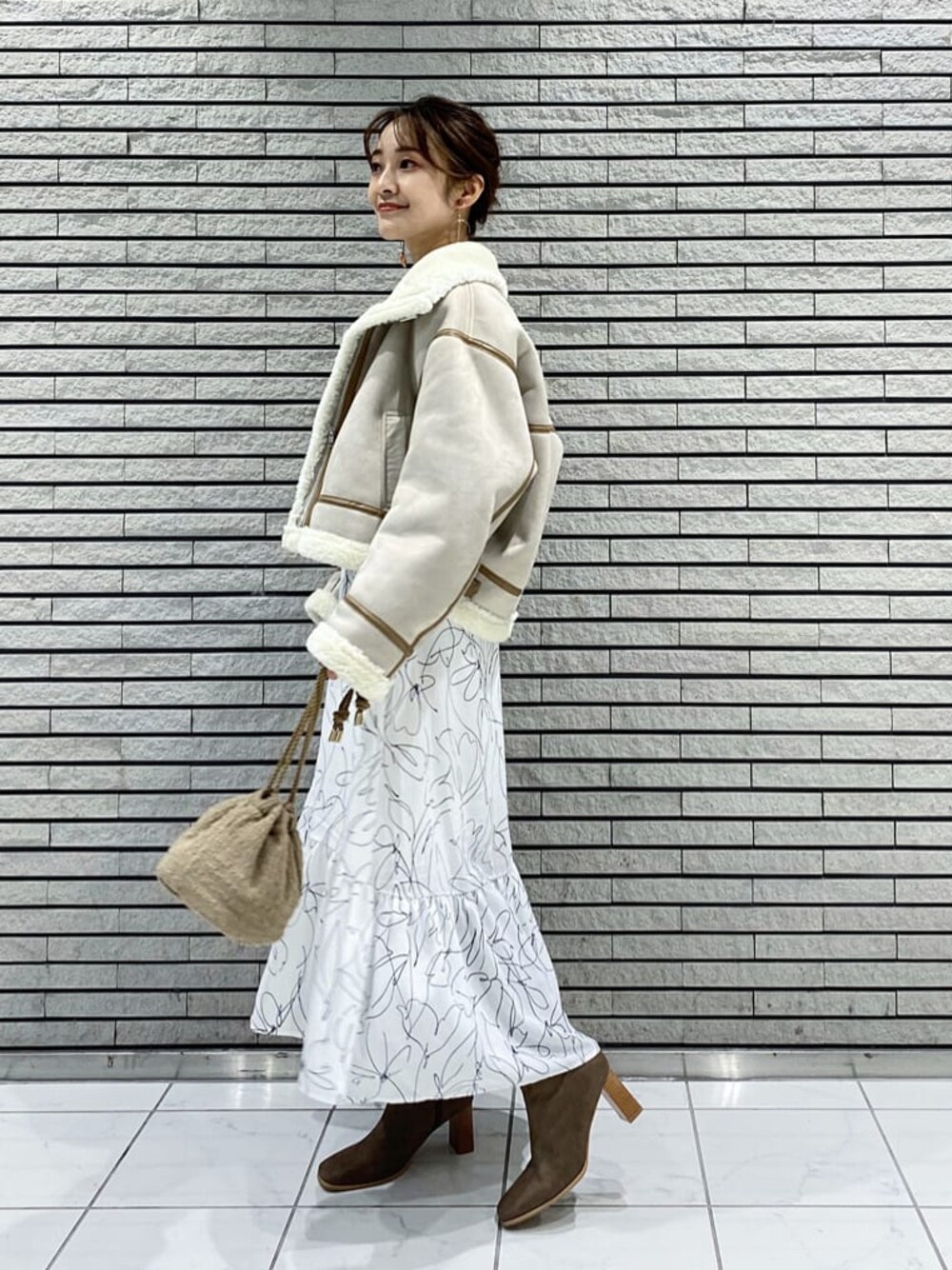 ベージュ系のハンドバッグ、ベージュ系のTシャツ/カットソー、ブルー系のワンピースを着用したレディースの秋コーディネートの1枚目の写真