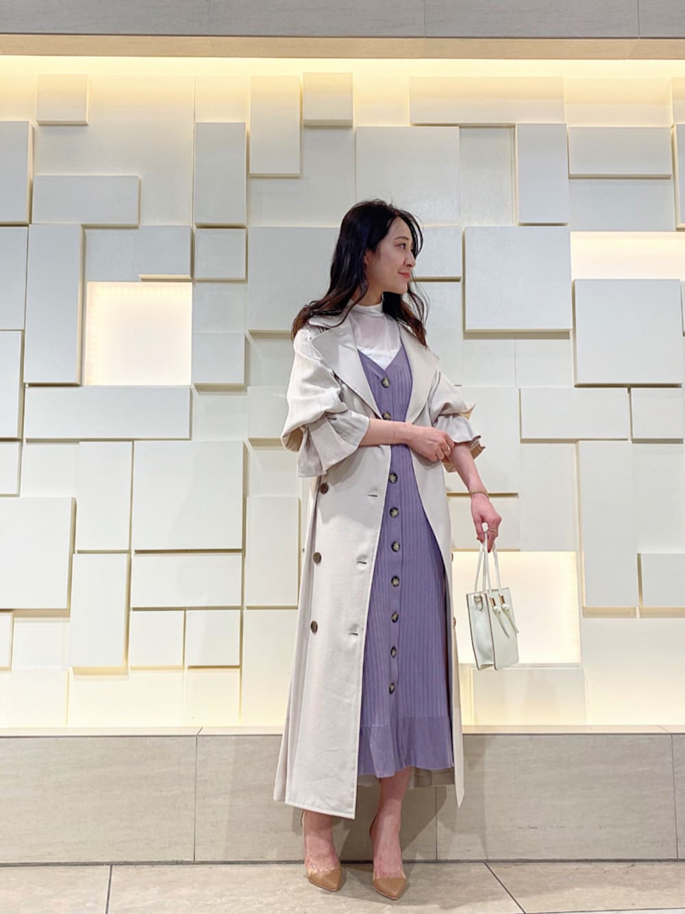 ベージュ系のパンプス、ベージュ系のトレンチコート、パープル系のワンピースを着用したレディースの春コーディネートの1枚目の写真