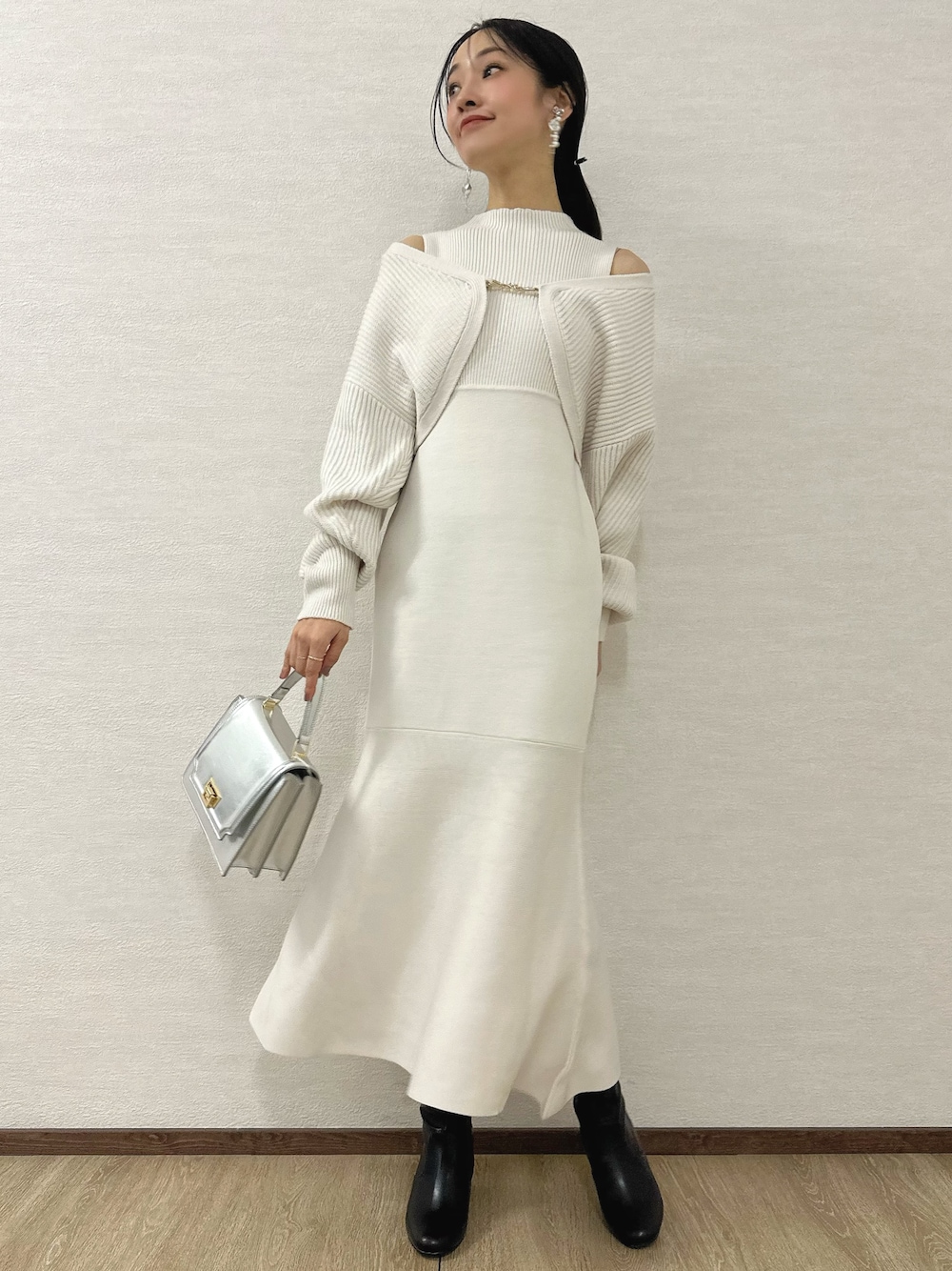 ホワイト系のワンピース、シルバー系のハンドバッグ、ブラック系のブーツを着用したレディースの秋コーディネートの1枚目の写真