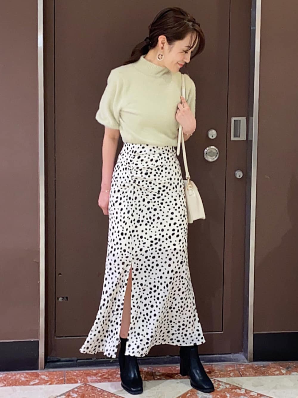 ベージュ系のイヤリングを着用したレディースの秋コーディネートの1枚目の写真