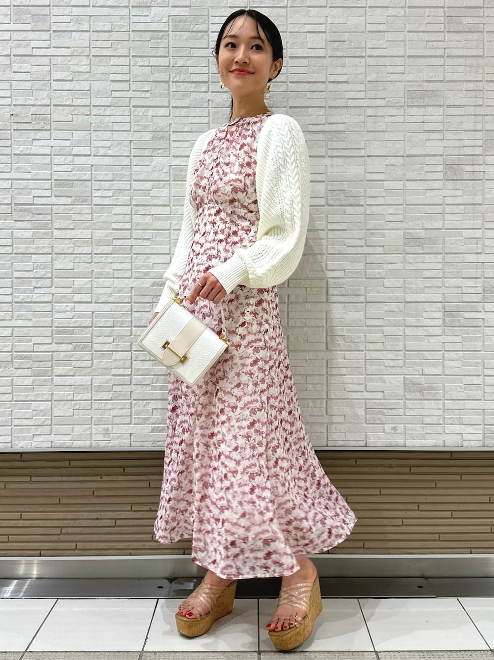 ホワイト系のカーディガン/ボレロ、ホワイト系のハンドバッグ、ピンク系のワンピースを着用したレディースの春コーディネートの1枚目の写真