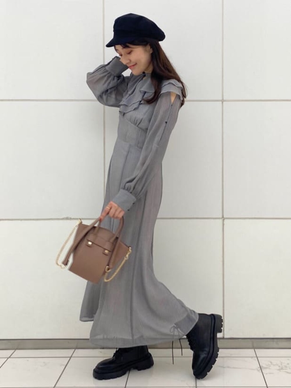 ブラック系のブーツ、ブラウン系のハンドバッグ、ブラック系のワンピースを着用したレディースの夏コーディネートの1枚目の写真