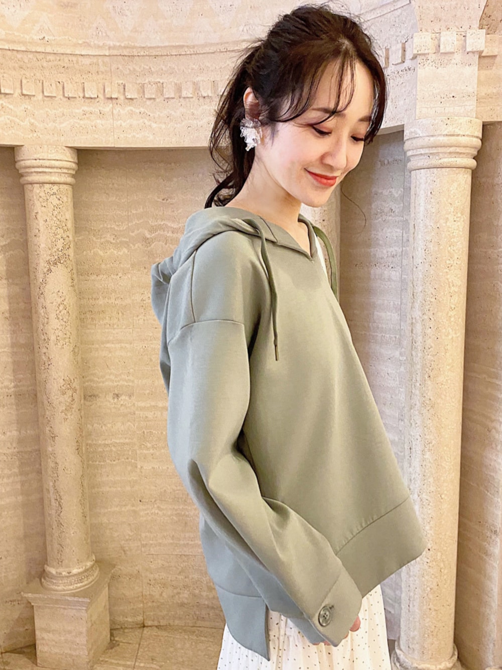 ホワイト系のスカート、ブラック系のローファー、ホワイト系のハンドバッグを着用したレディースの冬コーディネートの1枚目の写真