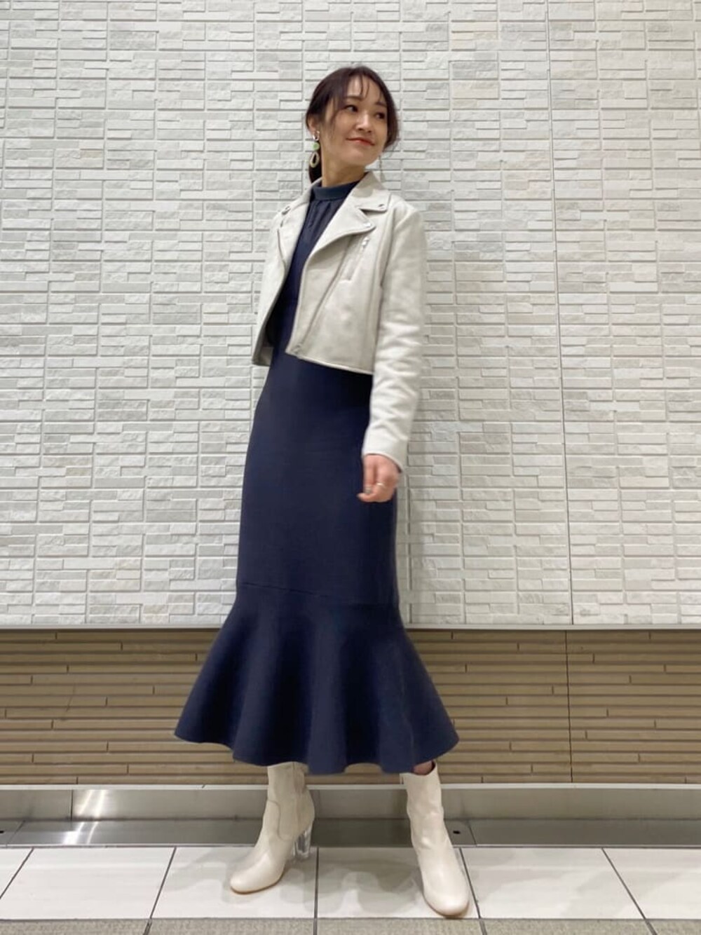 グレー系のテーラードジャケット、ブルー系のワンピース、ホワイト系のその他シューズを着用したレディースの冬コーディネートの1枚目の写真