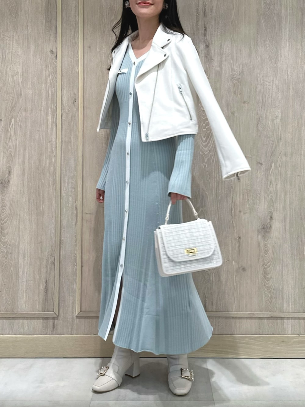 ホワイト系のハンドバッグ、ホワイト系のブーツ、ブルー系のワンピースを着用したレディースの冬コーディネートの1枚目の写真
