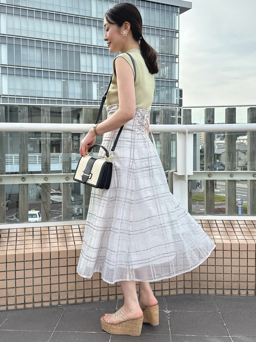 その他のサンダル、ブラック系のハンドバッグ、グリーン系のワンピースを着用したレディースの春コーディネートの1枚目の写真