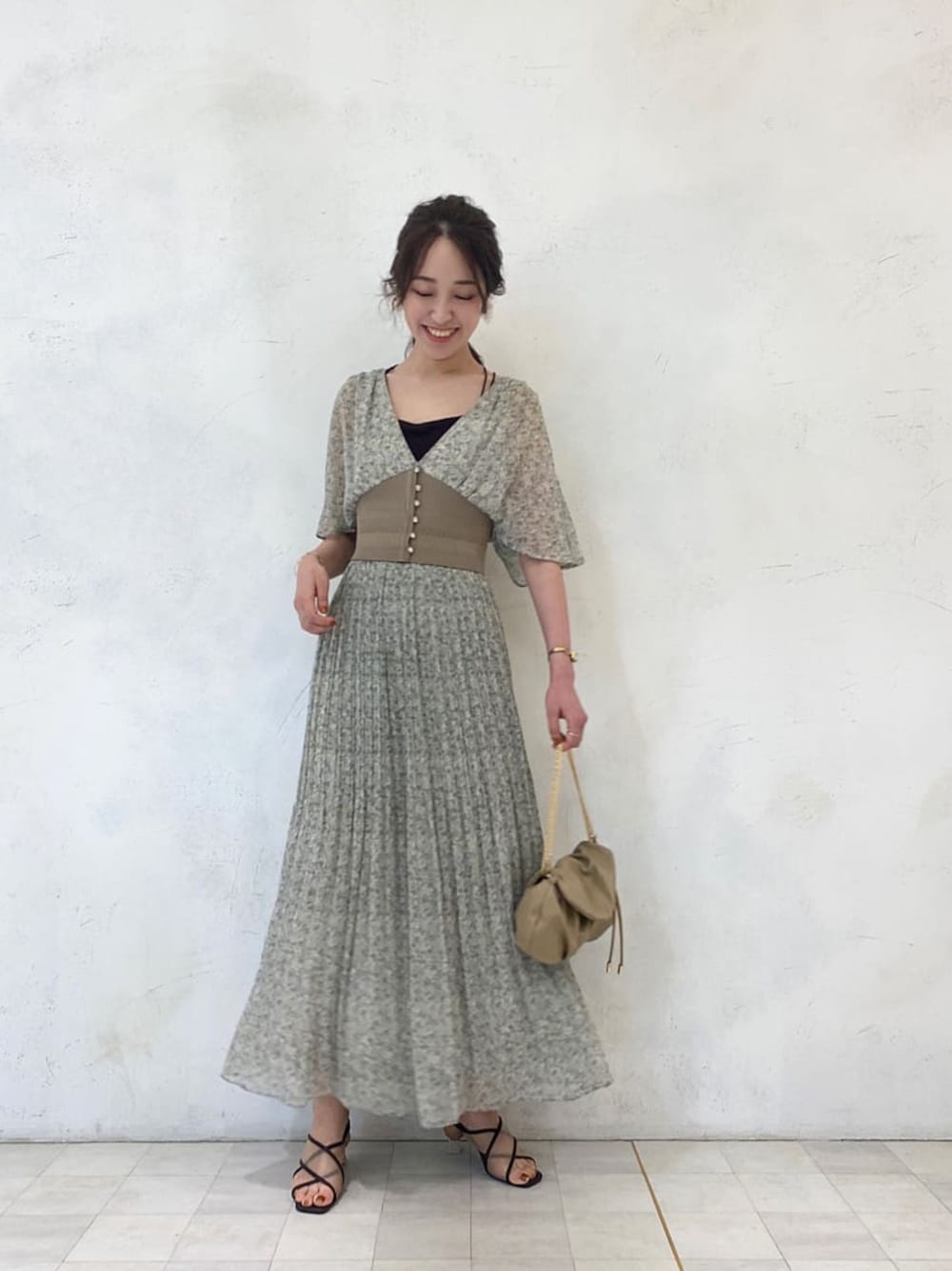 グリーン系のシャツ/ブラウス、ベージュ系のクラッチバッグ、グリーン系のスカートを着用したレディースの夏コーディネートの1枚目の写真