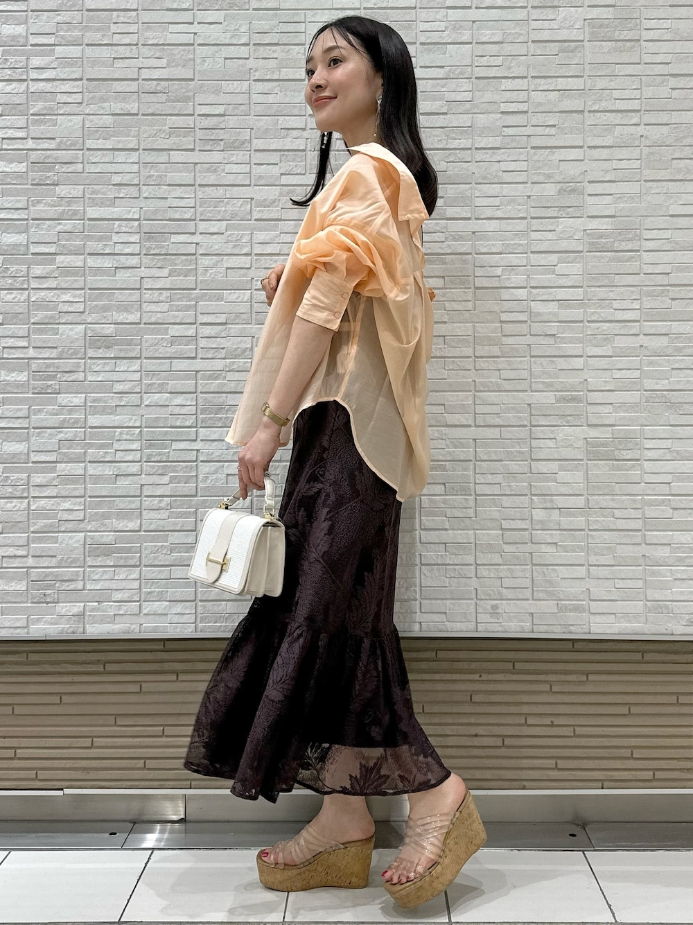 「MERCURYDUO(MERCURYDUO)、MERCURYDUO、マーキュリーデュオ(MERCURYDUO)、マーキュリーデュオ、キャミワンピース、ブラウンコーデ、シアーシャツ、オレンジコーデ、キャミワンピ、お出かけコーデ、イエベ」｜「MERCURYDUOのクリアチューブウェッジサンダル（サンダル、その他）」を使った、村岡愛美さん（レディース・162cm）の春コーディネートの1枚目の写真