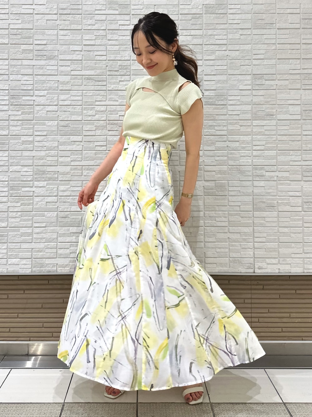 ホワイト系のキャミソール、ホワイト系のサンダル、イエロー系のスカートを着用したレディースの夏コーディネートの1枚目の写真