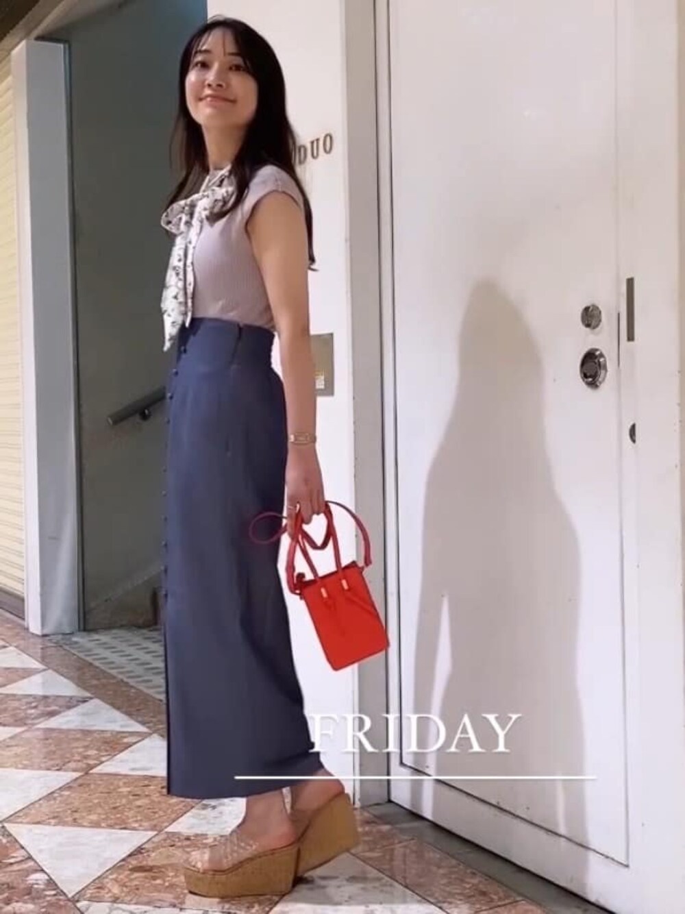 レッド系のハンドバッグ、その他のサンダル、ブルー系のスカートを着用したレディースの夏コーディネートの1枚目の写真