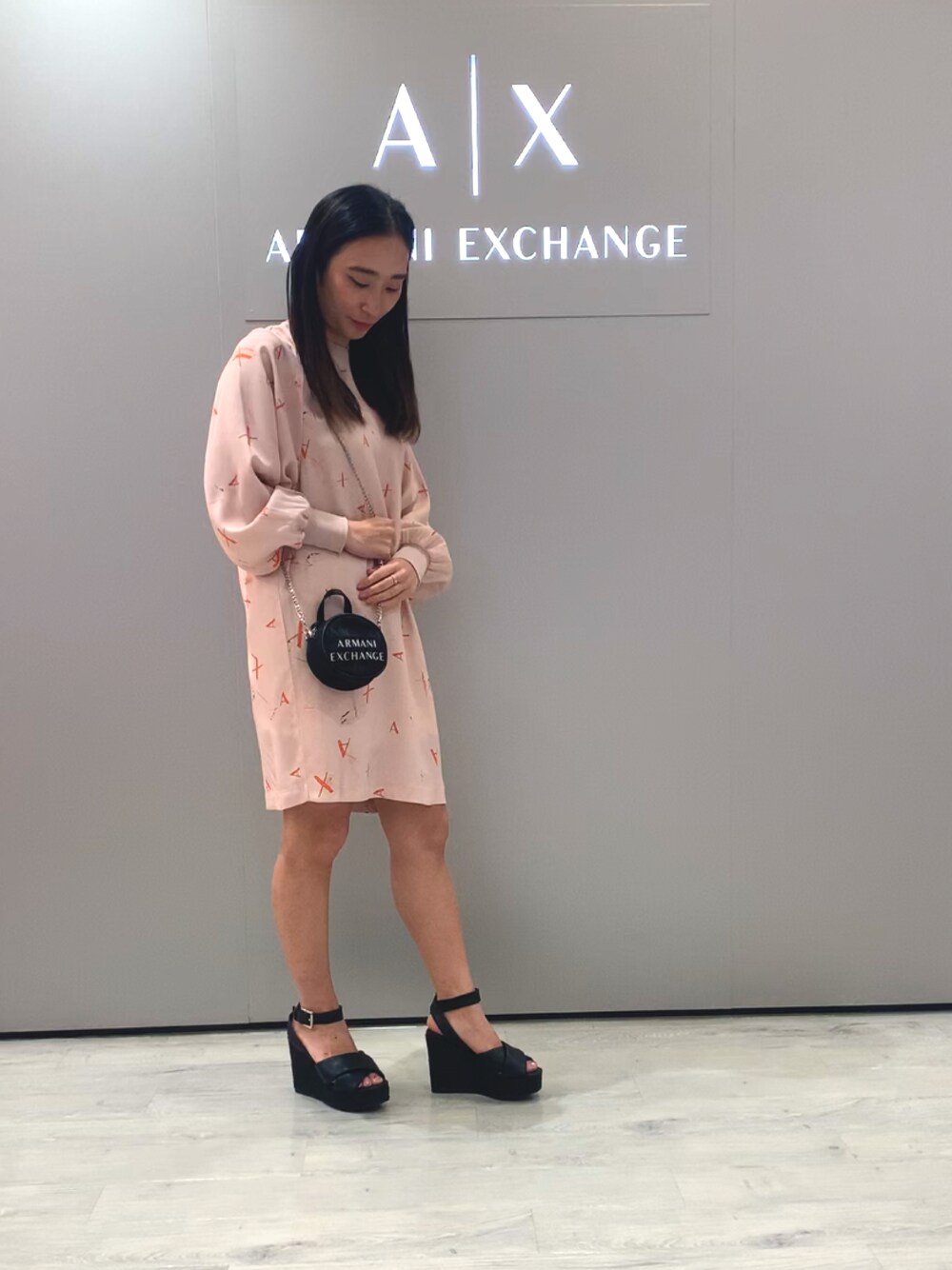 ブラック系のサンダル、ピンク系のワンピース、ブラック系のボディバッグ/ウエストポーチを着用したレディースの春コーディネートの1枚目の写真