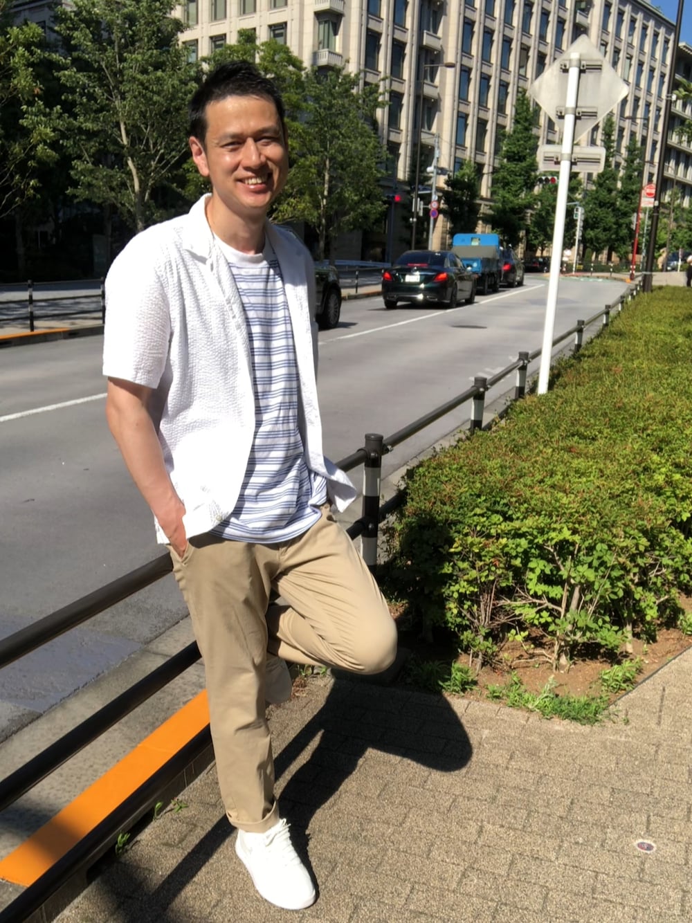 ホワイト系のスニーカー、ベージュ系のチノパンツ、ブルー系のTシャツ/カットソーを着用したメンズの夏コーディネートの1枚目の写真