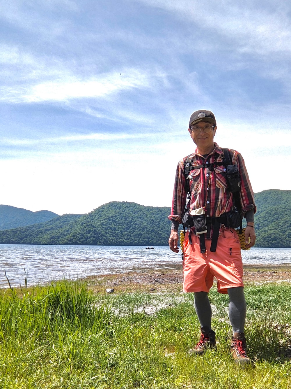 レッド系のシャツ/ブラウス、ブラウン系のブーツ、ホワイト系のバックパック/リュックを着用したメンズの夏コーディネートの1枚目の写真