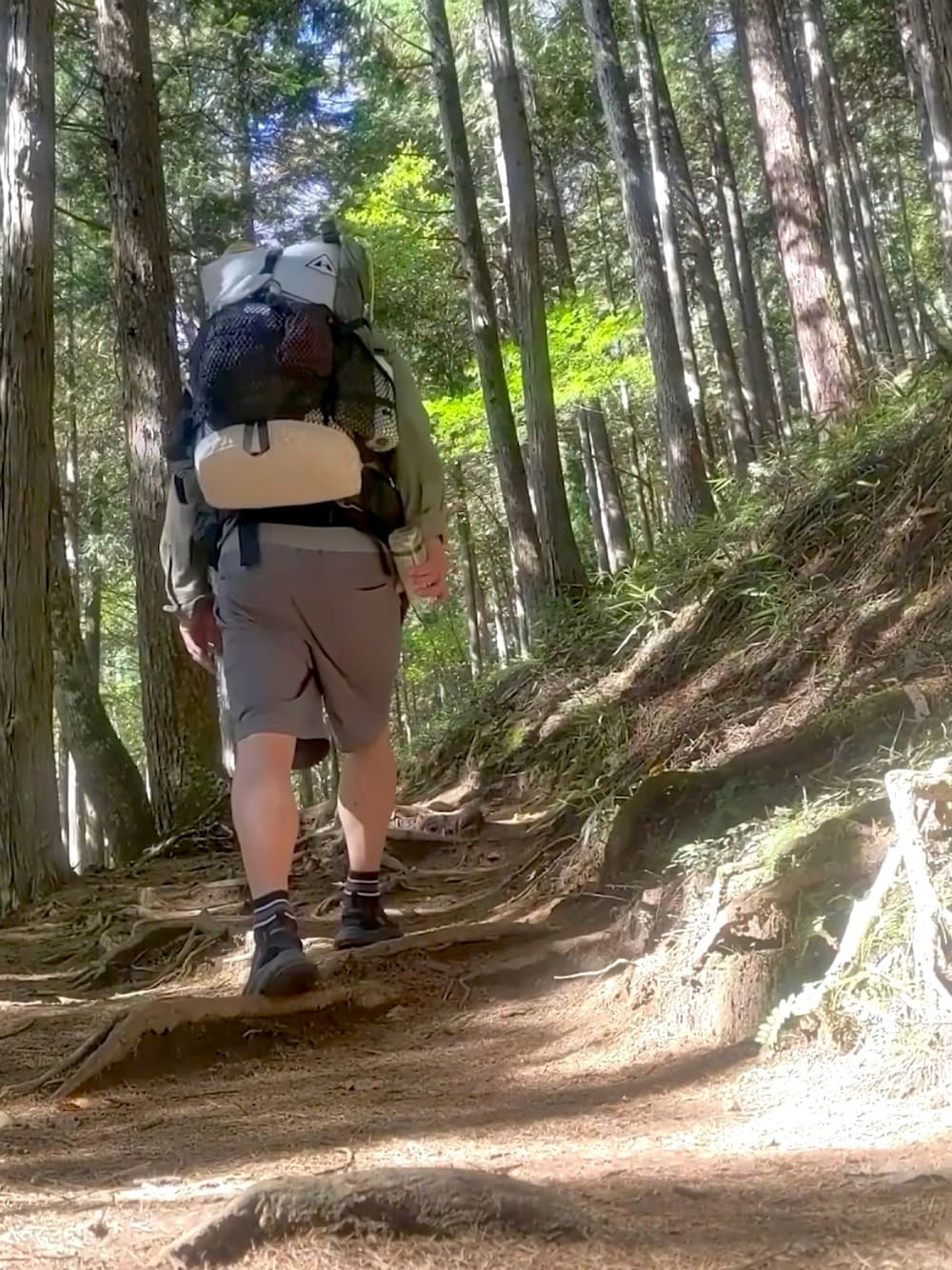 グレー系のその他パンツ、グリーン系のシャツ/ブラウス、ホワイト系のバックパック/リュックを着用したメンズの秋コーディネートの1枚目の写真