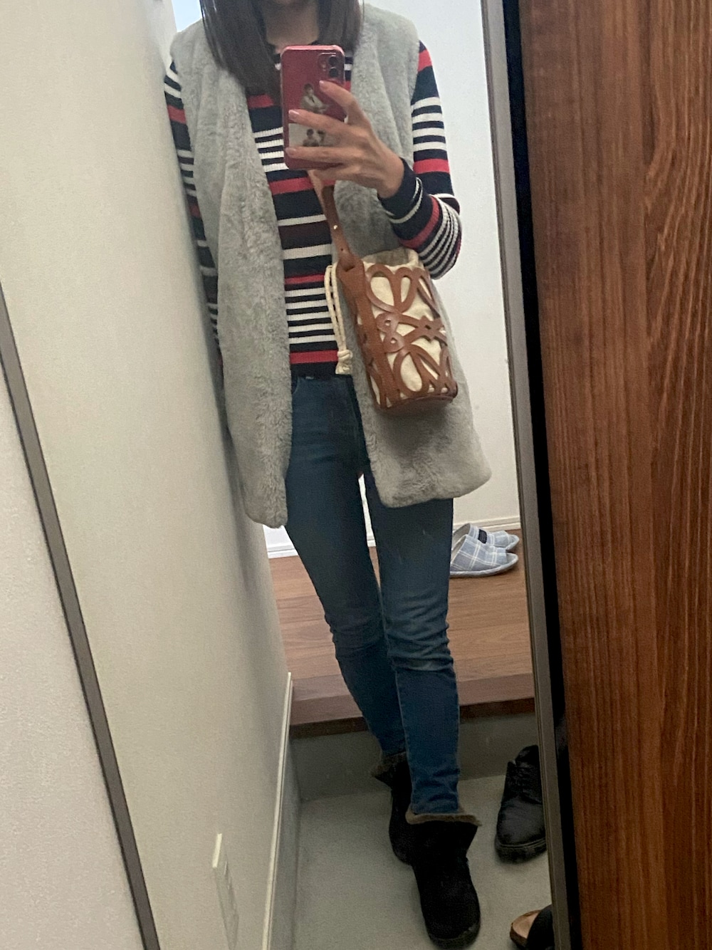 ブルー系のニット/セーター、グレー系のその他アウター、ブルー系のデニムパンツを着用したレディースの秋コーディネートの1枚目の写真