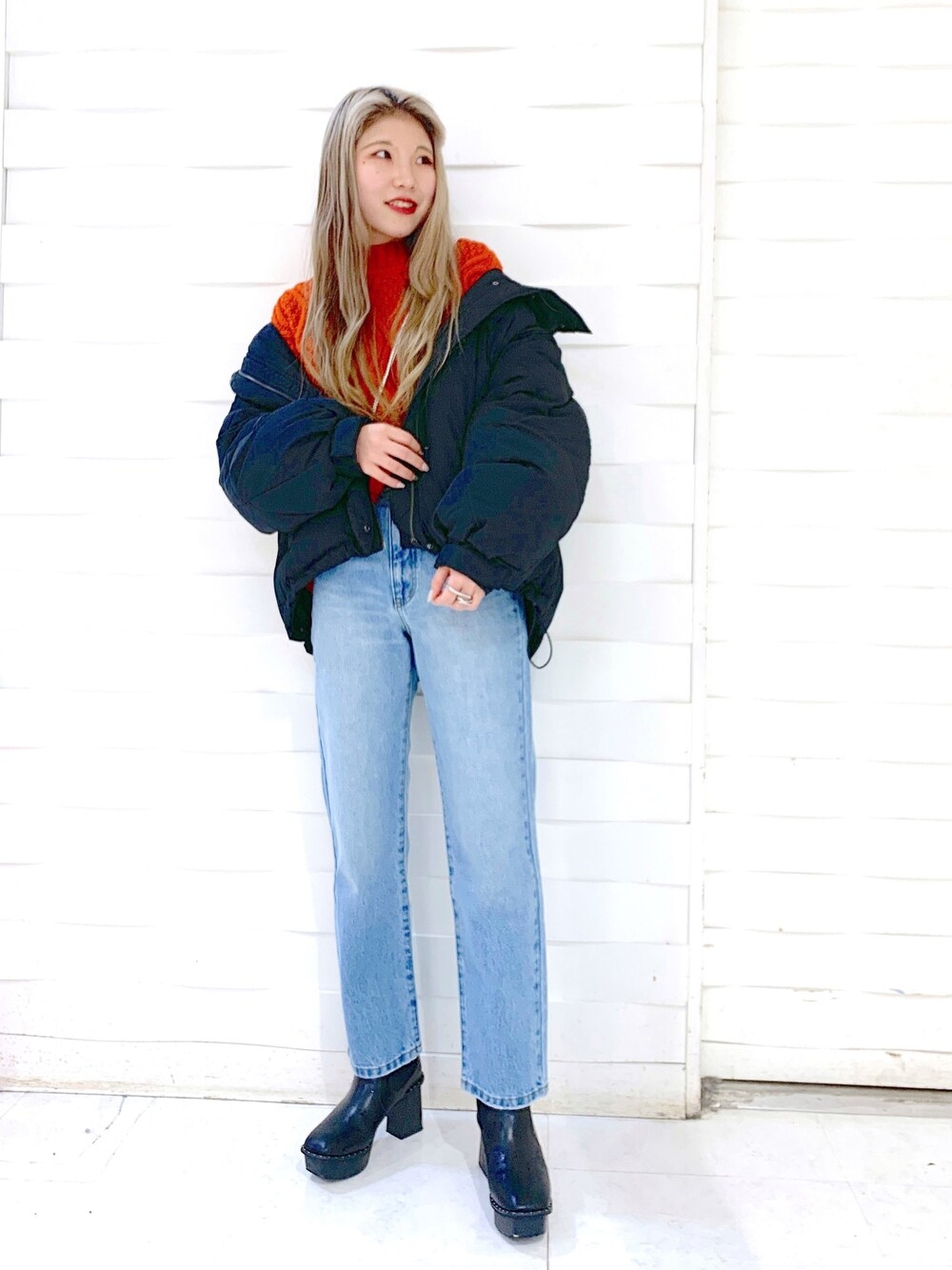 ブラック系のブルゾン、ブルー系のデニムパンツ、ブラック系のブーツを着用したレディースの冬コーディネートの2枚目の写真