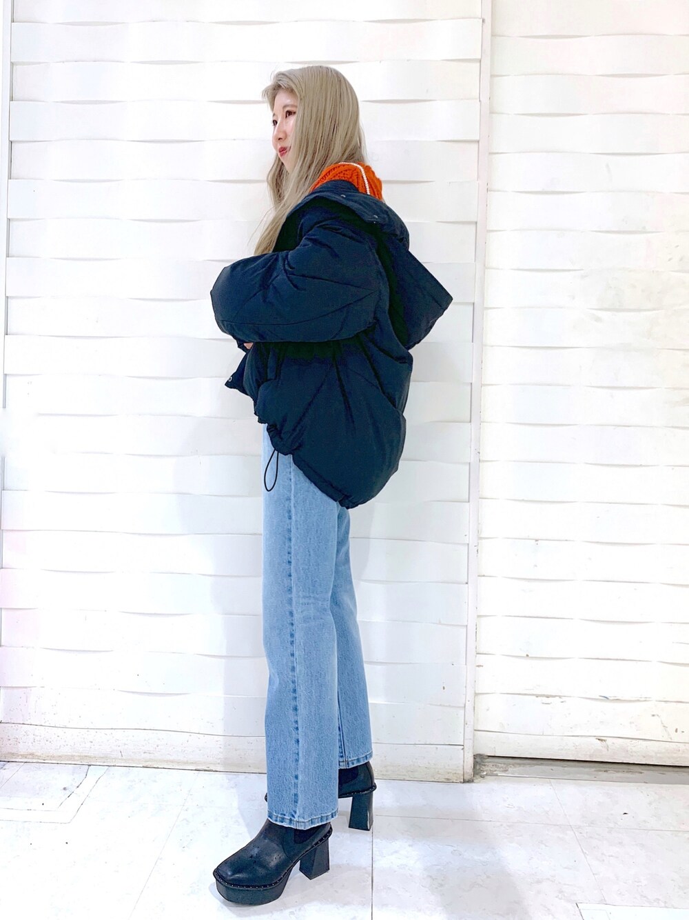 ブラック系のブルゾン、ブルー系のデニムパンツ、ブラック系のブーツを着用したレディースの冬コーディネートの3枚目の写真