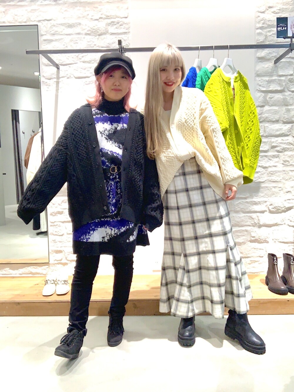 グリーン系のニット/セーター、ホワイト系のスカート、ブラック系のワンピースを着用したレディースの冬コーディネートの2枚目の写真