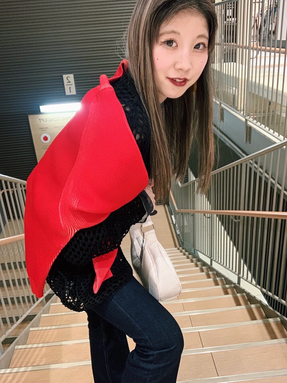 レッド系のカーディガン/ボレロ、ブラック系のデニムパンツ、ブラック系のその他シューズを着用したレディースの春コーディネートの2枚目の写真