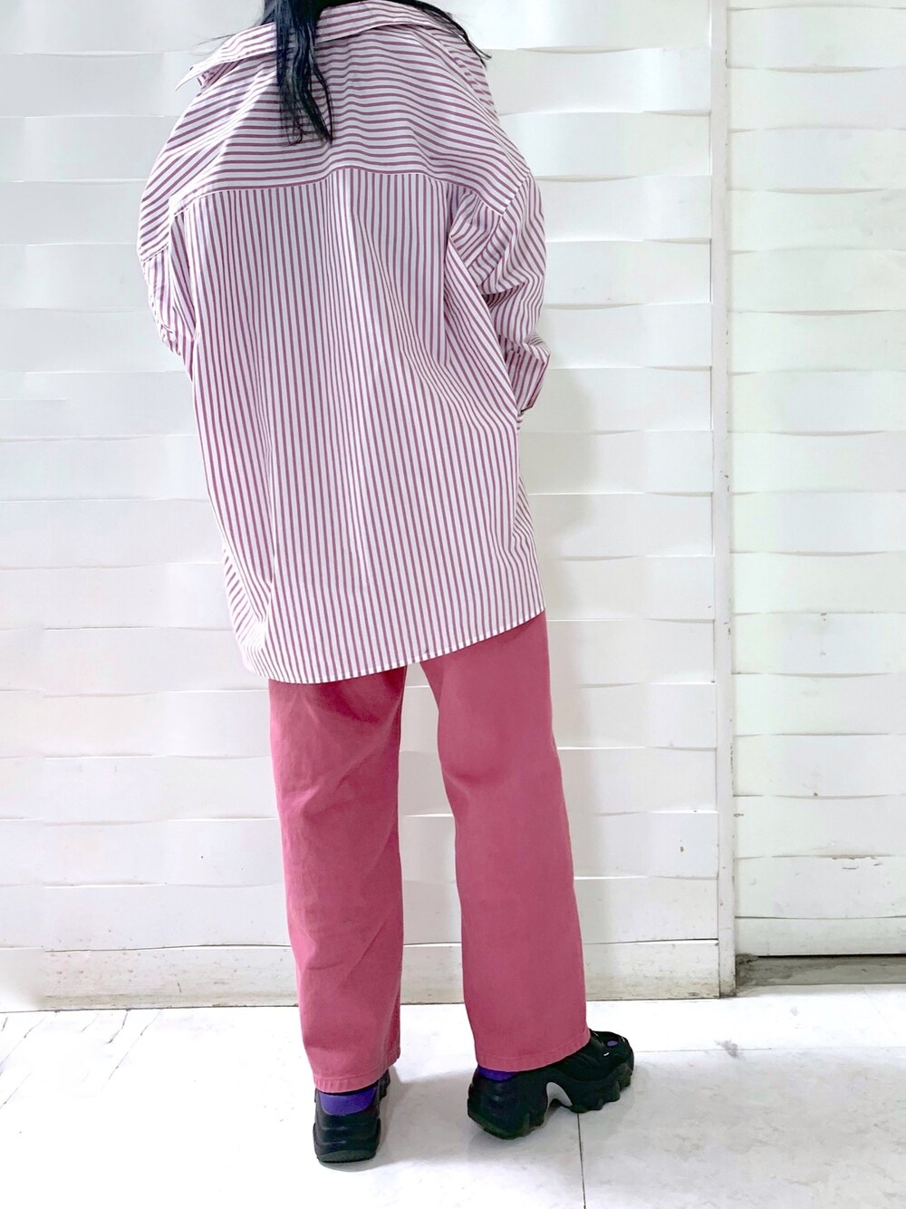 ピンク系のデニムパンツ、ブラック系のトップス、ブラック系のニット/セーターを着用したレディースの冬コーディネートの3枚目の写真