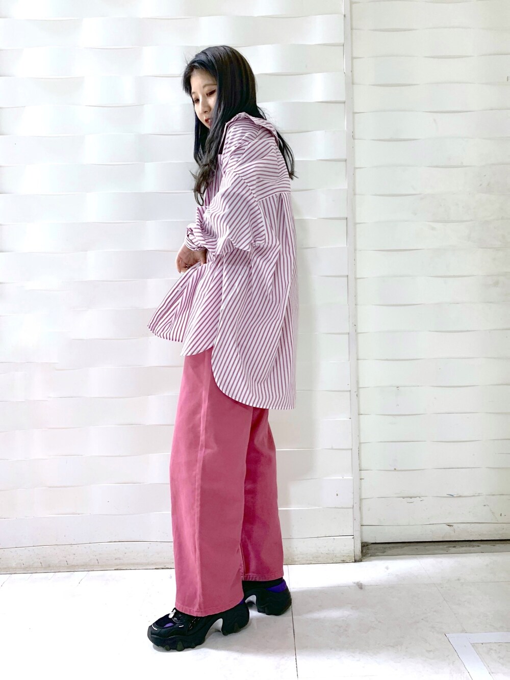 ピンク系のデニムパンツ、ブラック系のトップス、ブラック系のニット/セーターを着用したレディースの冬コーディネートの2枚目の写真