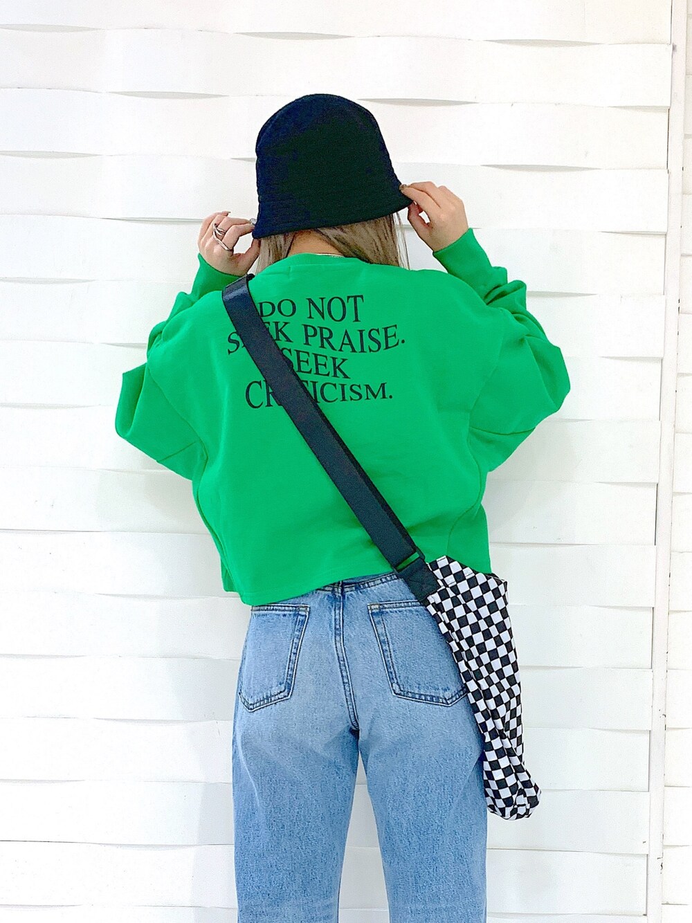 ブルー系のデニムパンツ、ブラック系のブーツ、ブラック系のショルダーバッグを着用したレディースの冬コーディネートの4枚目の写真