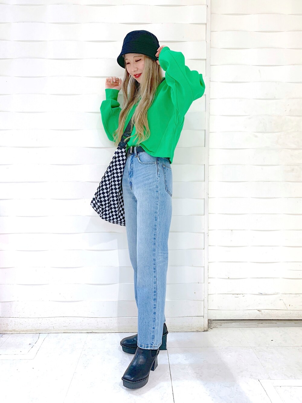 ブルー系のデニムパンツ、ブラック系のブーツ、ブラック系のショルダーバッグを着用したレディースの冬コーディネートの3枚目の写真