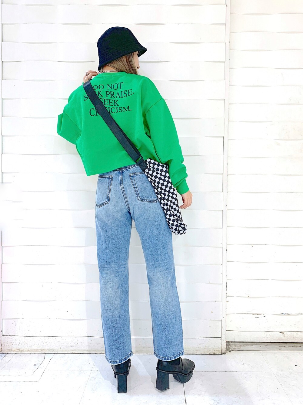 ブルー系のデニムパンツ、ブラック系のブーツ、ブラック系のショルダーバッグを着用したレディースの冬コーディネートの2枚目の写真