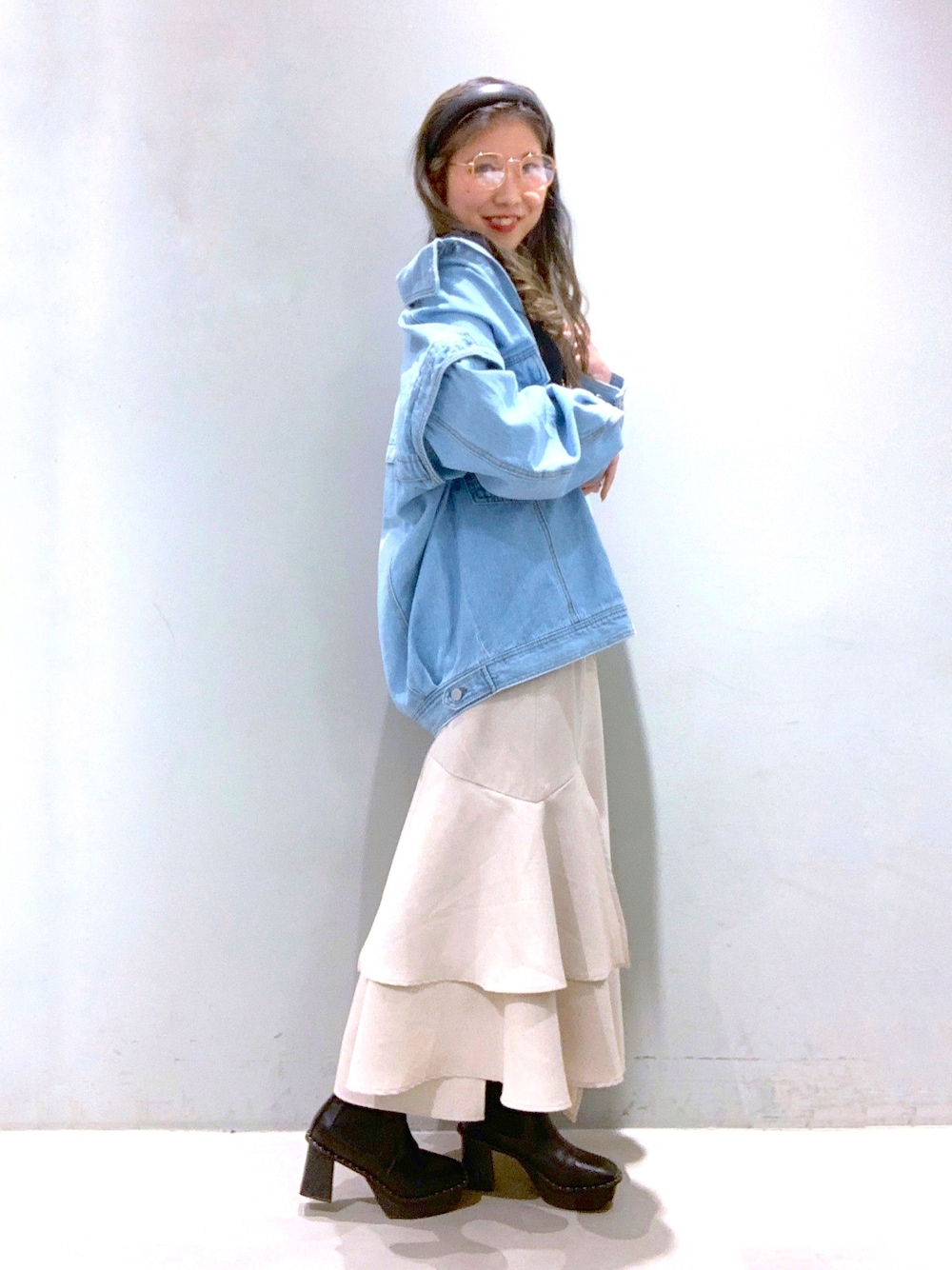 ブルー系のデニムジャケット、ピンク系のTシャツ/カットソー、ベージュ系のスカートを着用したレディースの冬コーディネートの2枚目の写真