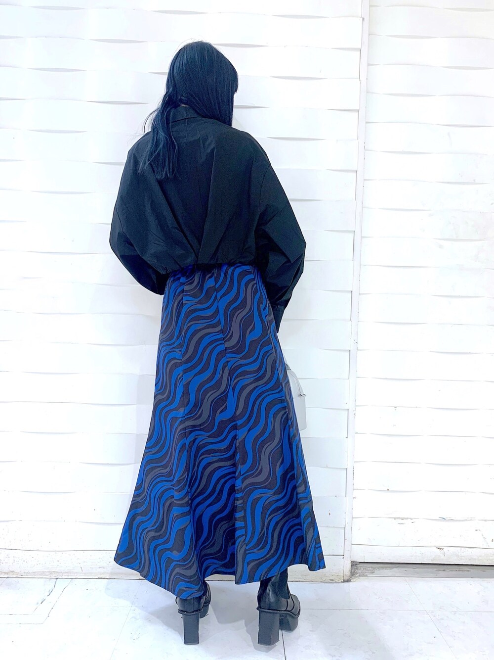 ホワイト系のスカート、シルバー系のショルダーバッグ、ブラック系のトップスを着用したレディースの冬コーディネートの5枚目の写真