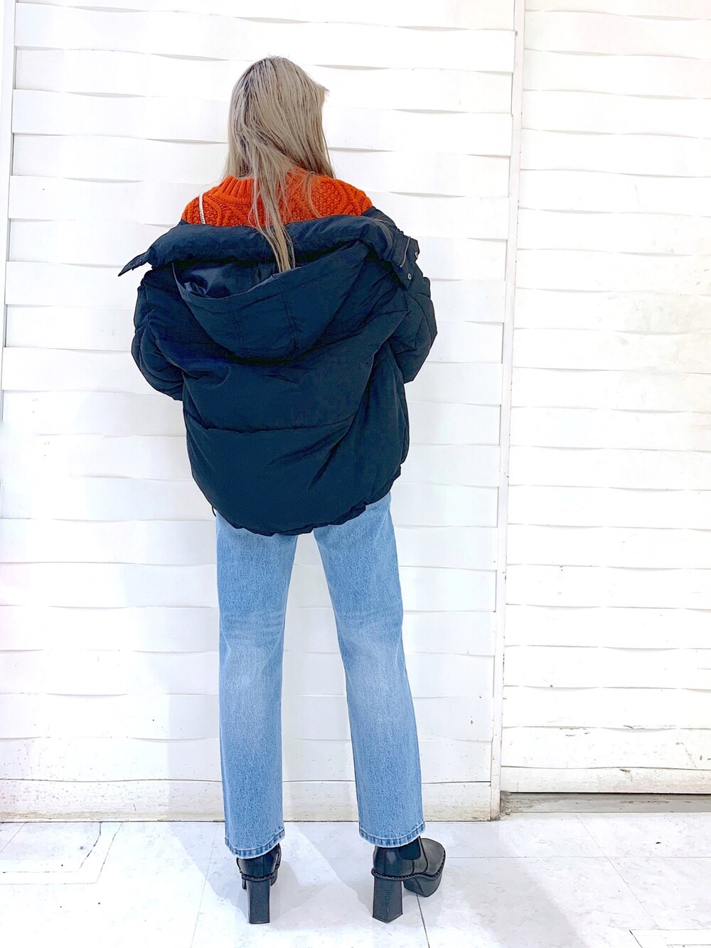 ブラック系のブルゾン、ブルー系のデニムパンツ、ブラック系のブーツを着用したレディースの冬コーディネートの4枚目の写真