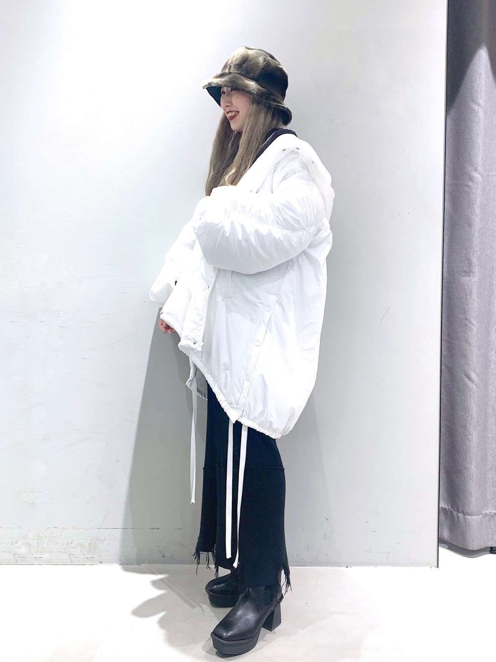 ホワイト系のブルゾン、グリーン系のニット/セーター、ブラック系のスカートを着用したレディースの冬コーディネートの3枚目の写真