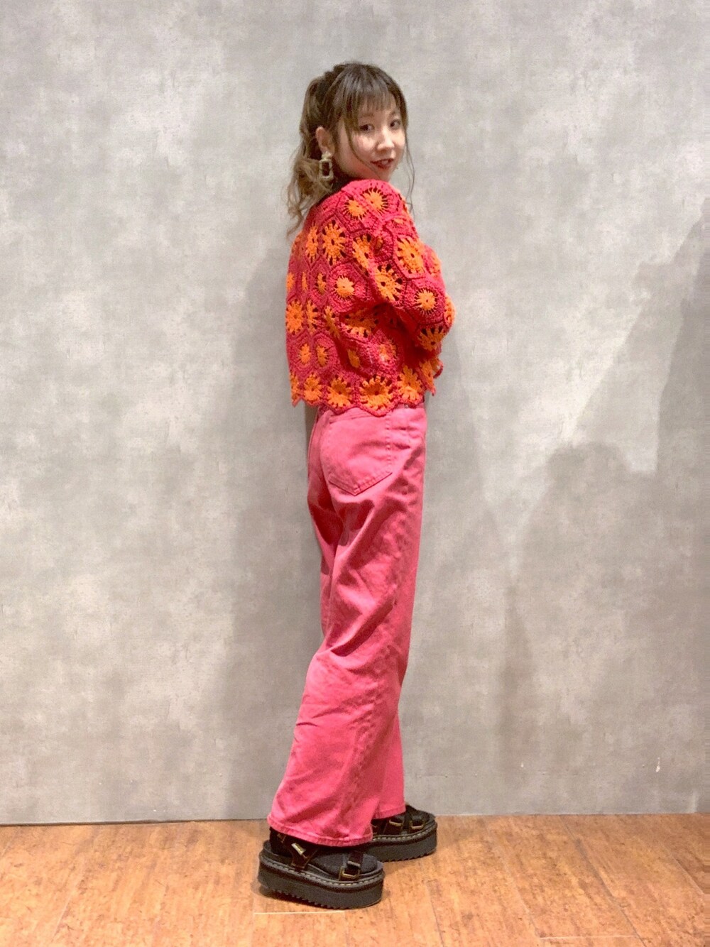 ピンク系のデニムパンツ、ブラック系のその他シューズ、オレンジ系のカーディガン/ボレロを着用したレディースの春コーディネートの3枚目の写真