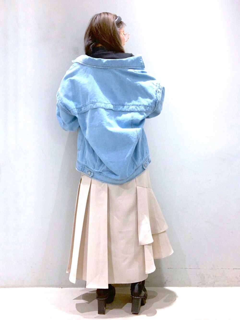 ブルー系のデニムジャケット、ピンク系のTシャツ/カットソー、ベージュ系のスカートを着用したレディースの冬コーディネートの3枚目の写真