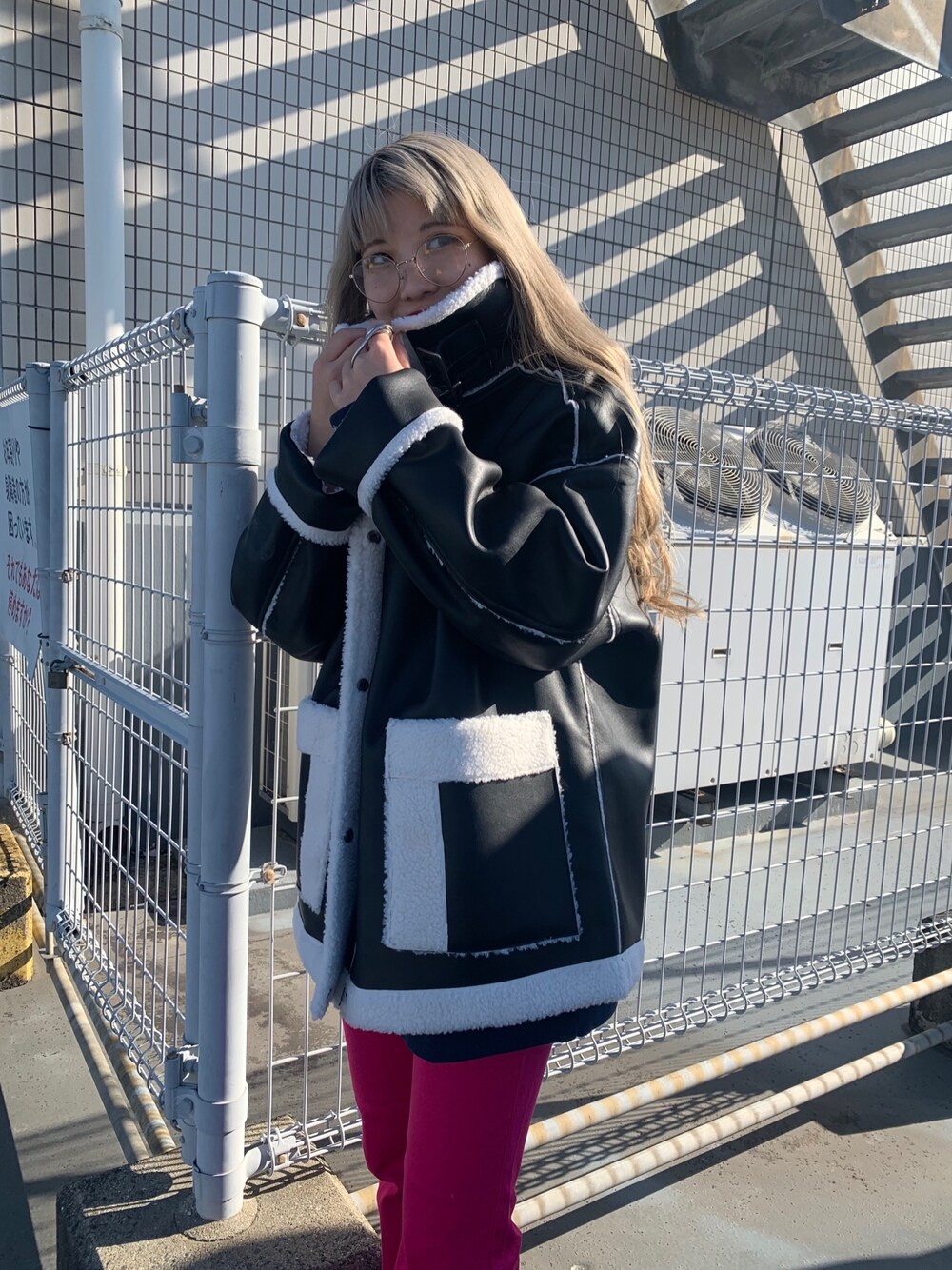 ブラウン系のブルゾン、ピンク系のデニムパンツ、ブルー系のスウェットを着用したレディースの冬コーディネートの2枚目の写真