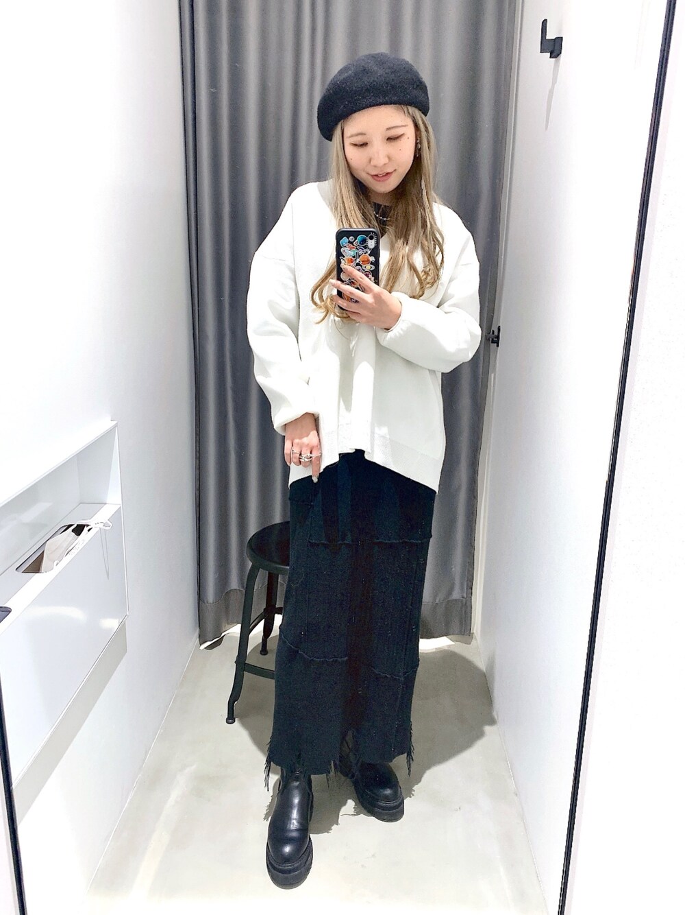 ブラック系のスカート、ホワイト系のニット/セーター、ブラック系のニット/セーターを着用したレディースの冬コーディネートの2枚目の写真