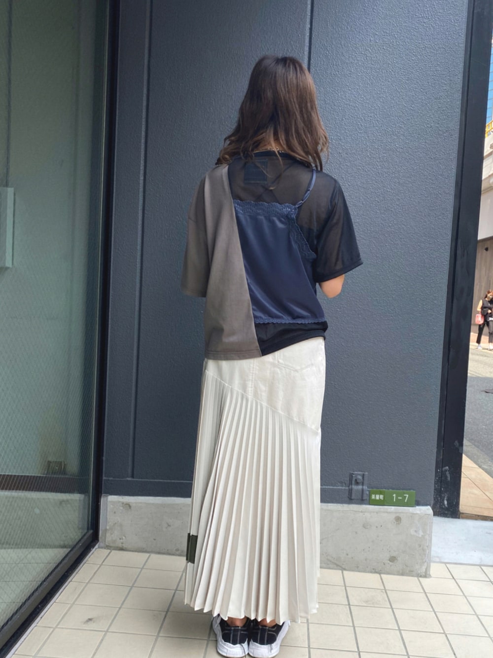 ホワイト系のスカート、ブラック系のTシャツ/カットソー、ブラック系のシューズを着用したレディースの夏コーディネートの1枚目の写真