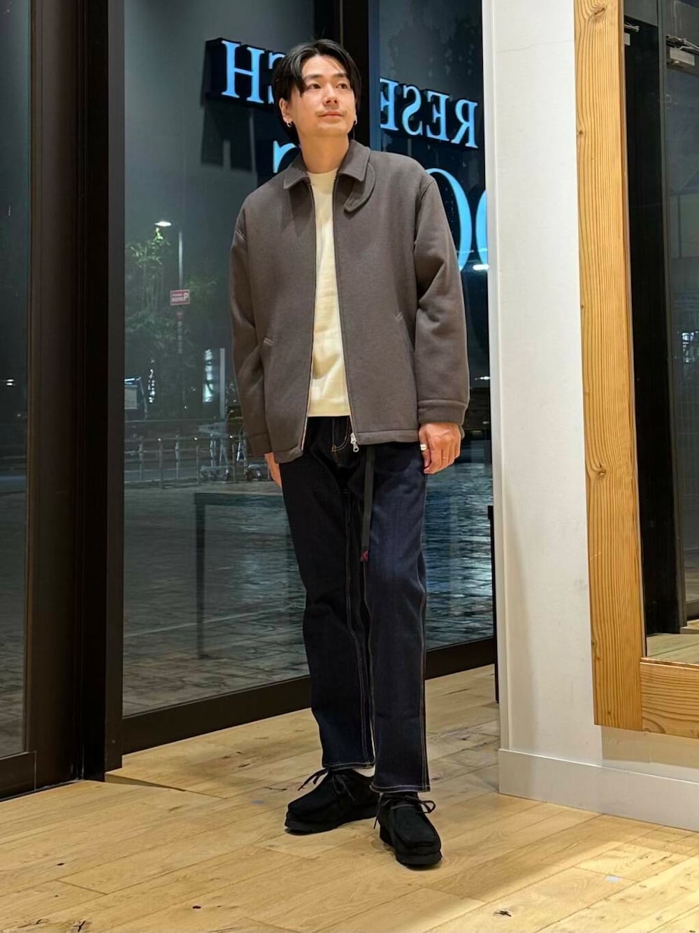 ブルー系のデニムパンツ、ブラック系のブーツ、ホワイト系のニット/セーターを着用したメンズの冬コーディネートの1枚目の写真