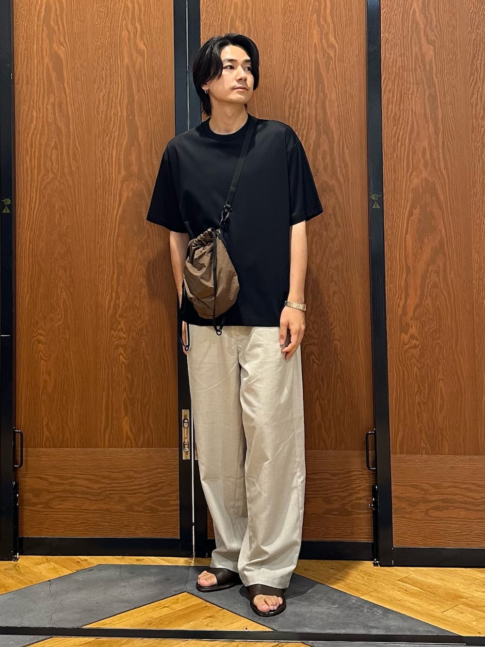 ブラック系のTシャツ/カットソー、ベージュ系のその他パンツ、ブラウン系のショルダーバッグを着用したメンズの夏コーディネートの1枚目の写真