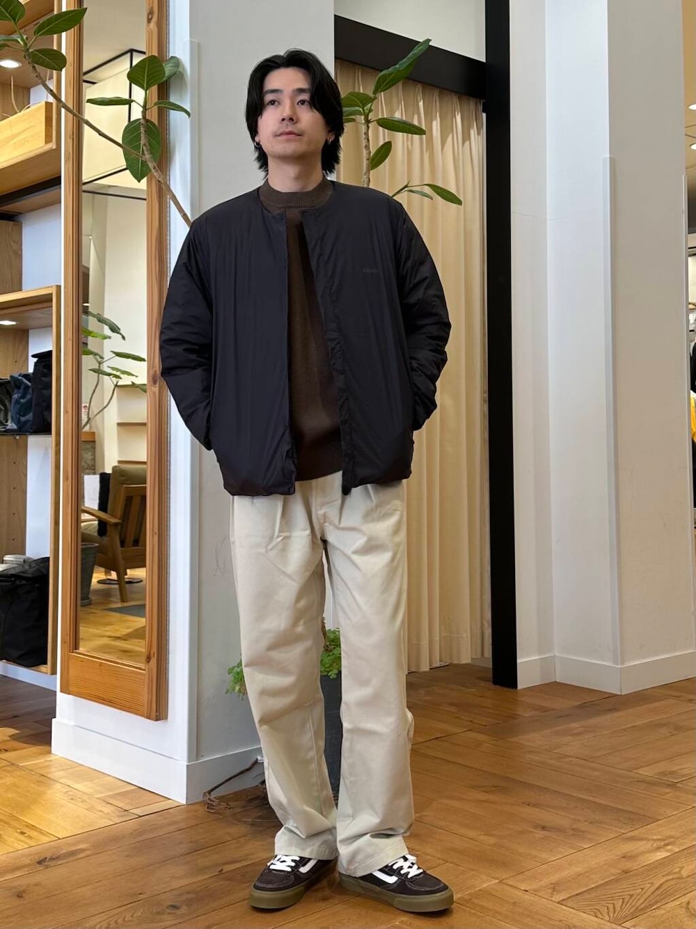 ホワイト系のチノパンツ、ブラック系のダウンジャケット/コート、ブラウン系のニット/セーターを着用したメンズの冬コーディネートの1枚目の写真